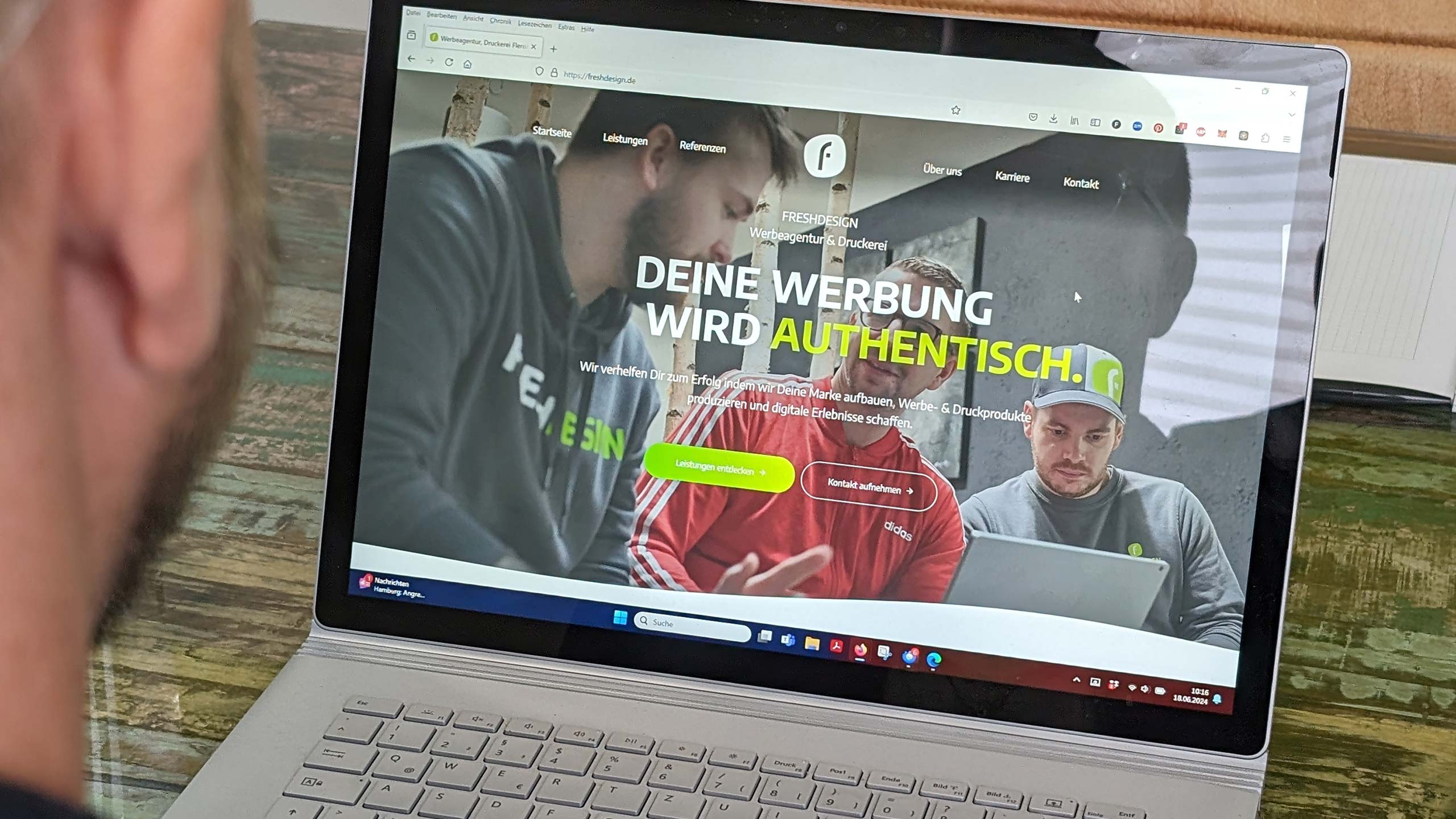 Ferdinand schaut auf einen Laptop-. Auf dem Bildschirm ist die Website von Freshdesign zu sehen